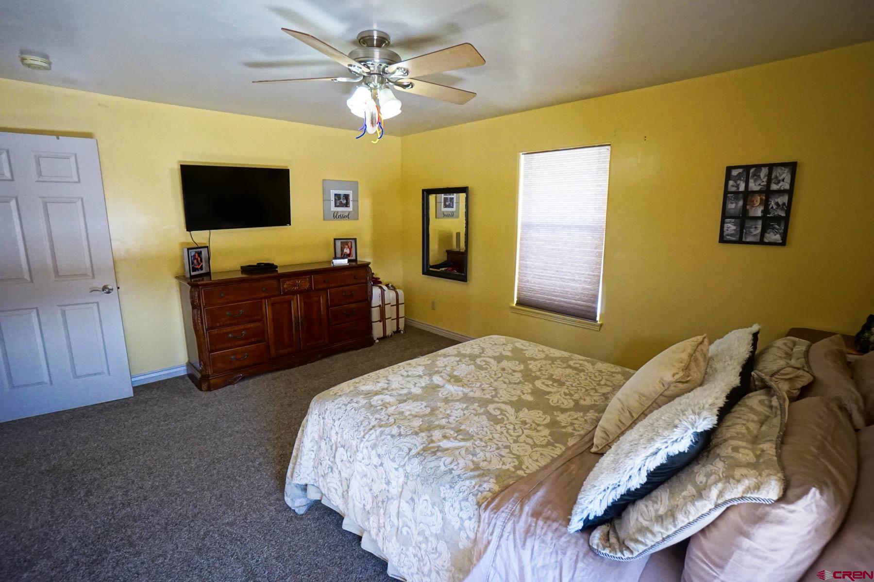 16575 2550th Road Cedaredge, CO 81413 - Photo 18 of 32 a bedroom with a bed and a flat screen tv
