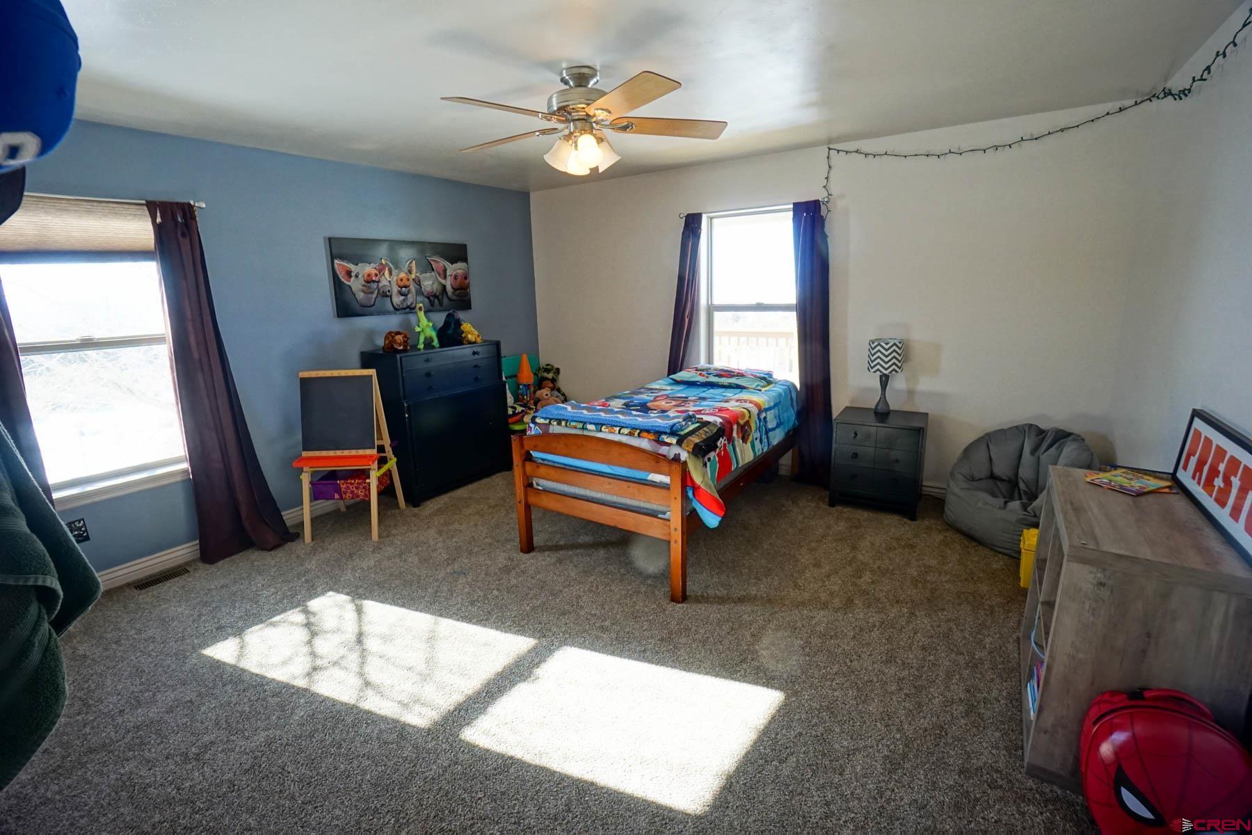 16575 2550th Road Cedaredge, CO 81413 - Photo 21 of 32 a bedroom with a bed and a chandelier