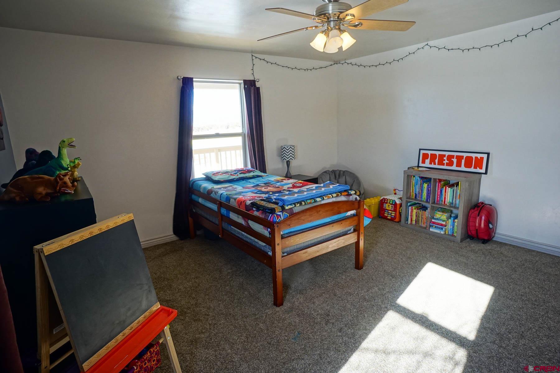 16575 2550th Road Cedaredge, CO 81413 - Photo 22 of 32 a bedroom with a bed and a chandelier