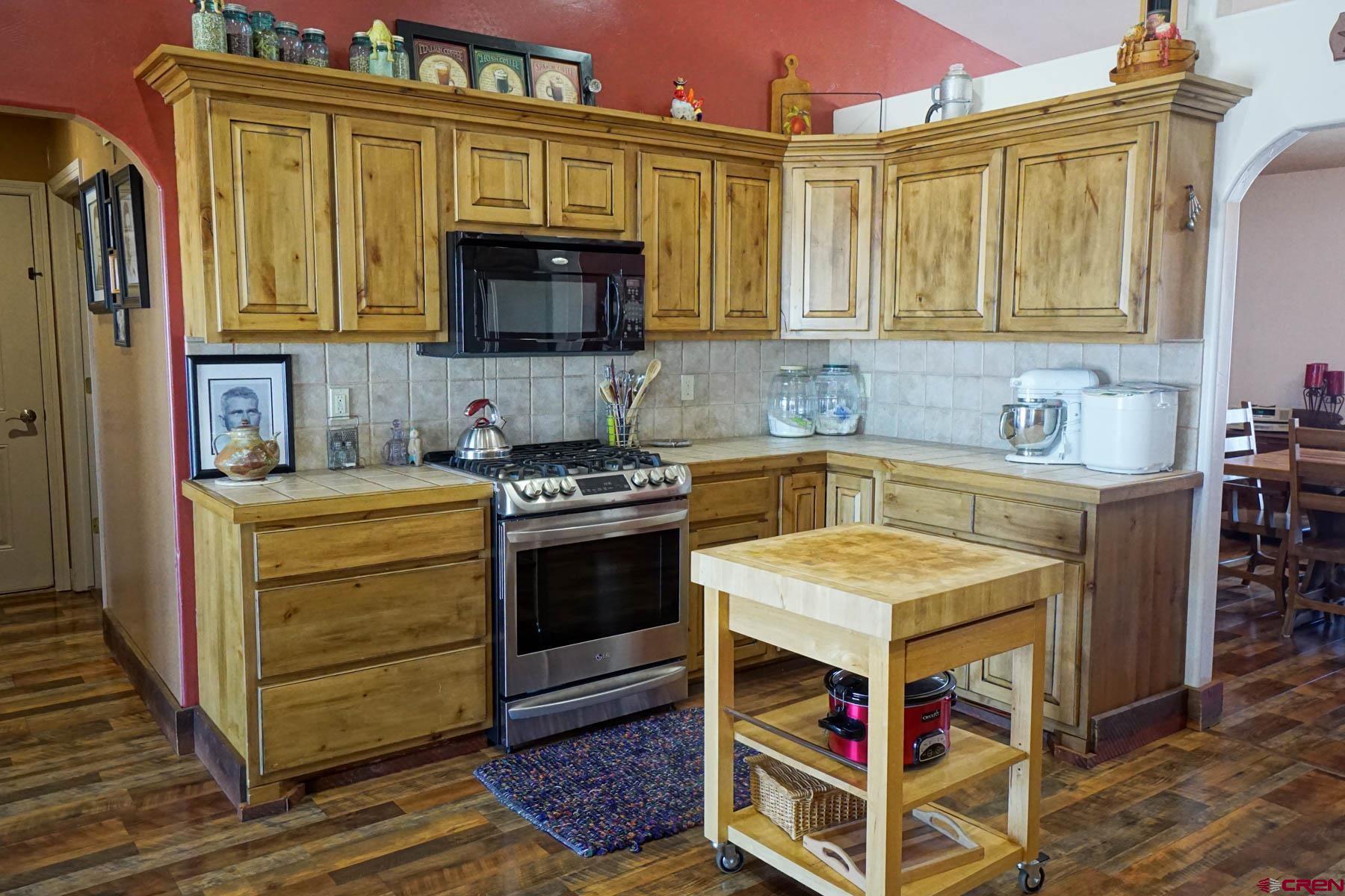16575 2550th Road Cedaredge, CO 81413 - Photo 9 of 32 a kitchen with stainless steel appliances a stove a sink and a microwave