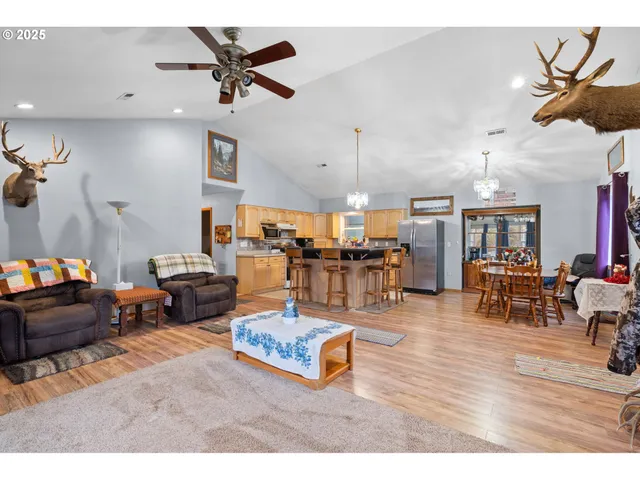 a living room with furniture kitchen view and a chandelier