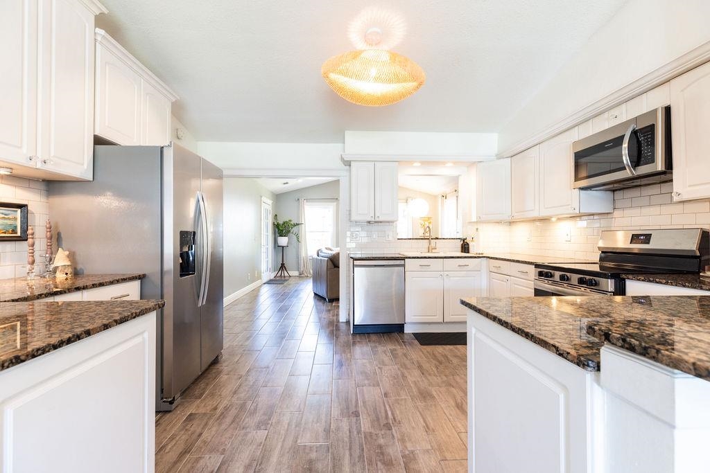 112 Drake Road St. Augustine, FL 32086 - Photo 8 of 59 a large kitchen with a center island wooden floor stainless steel appliances and cabinets