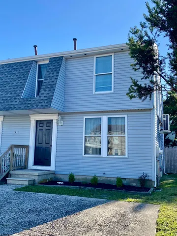a view of a house with a yard and potted plants