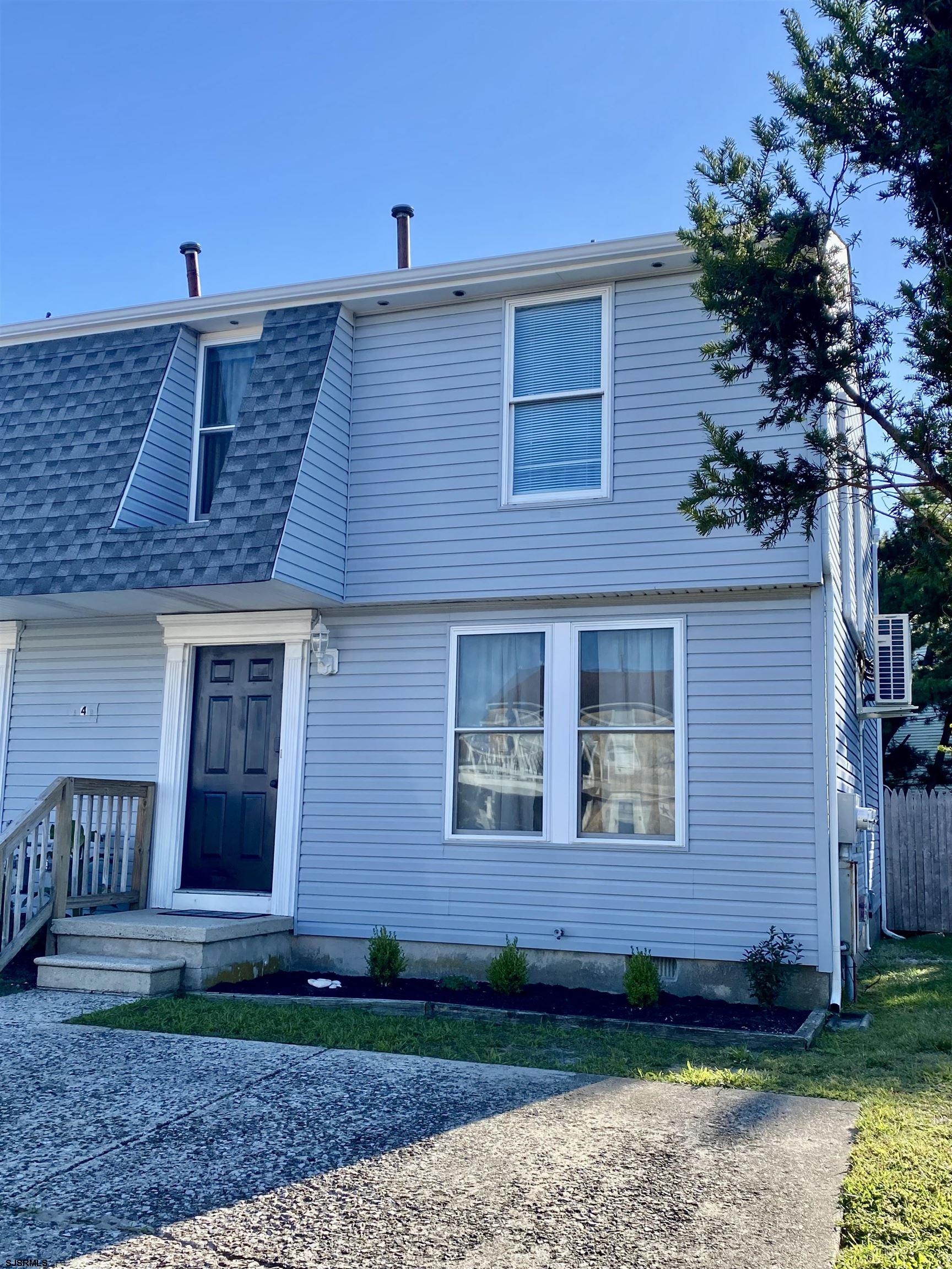 a view of a house with a yard and potted plants
