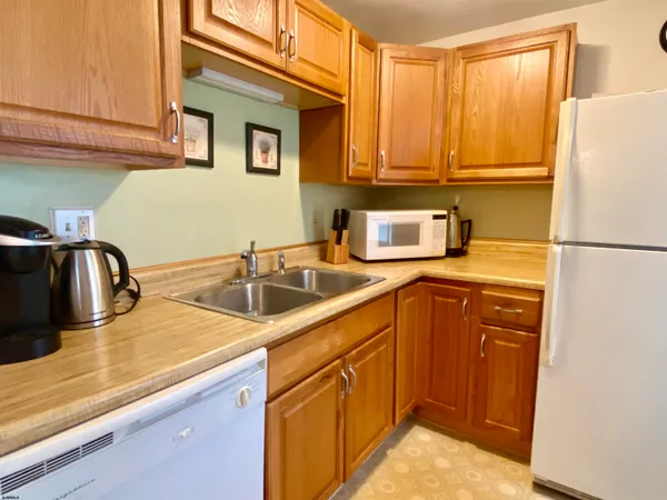 a kitchen with stainless steel appliances granite countertop a sink and a refrigerator