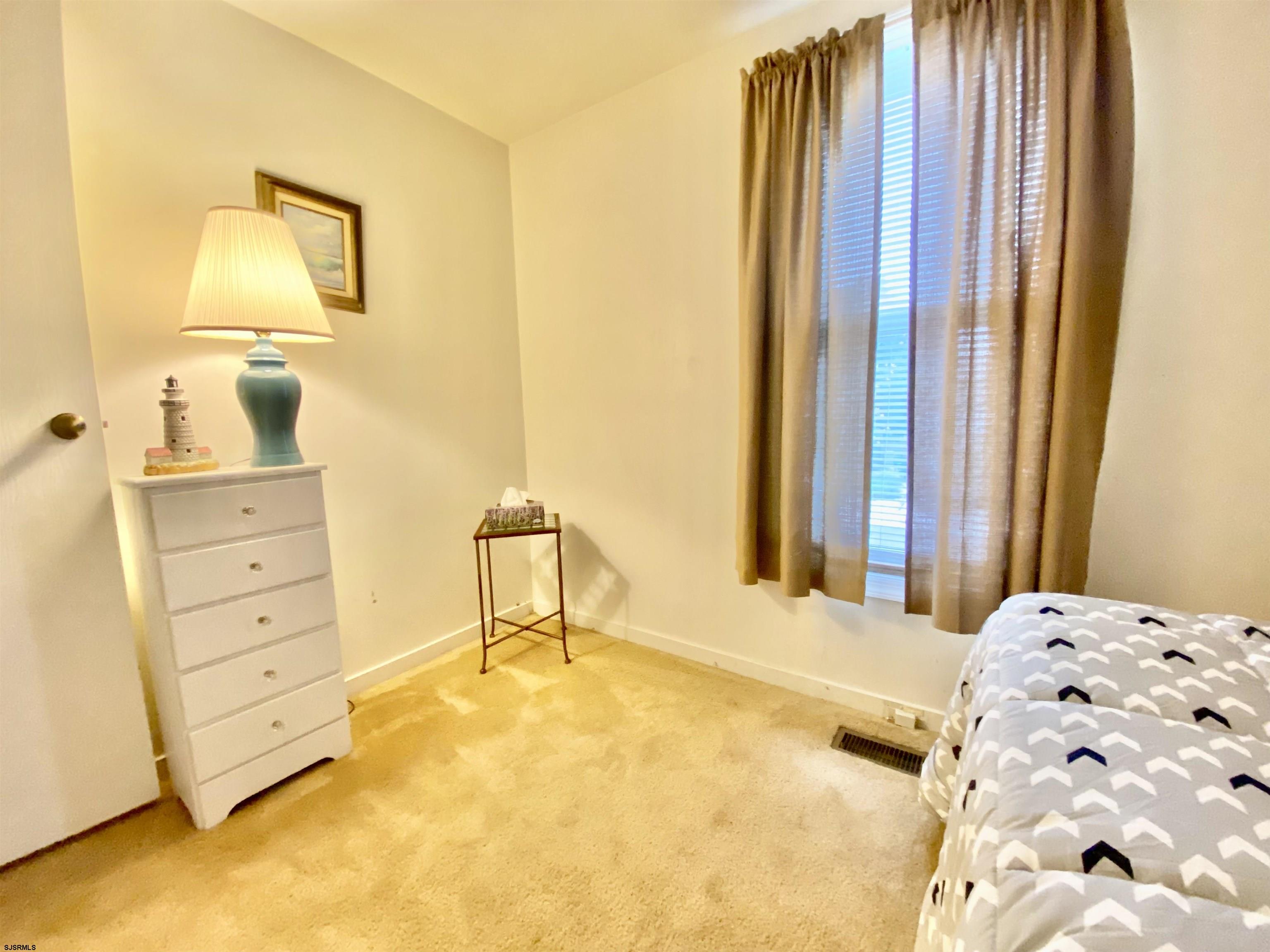 4 Ontario Drive, Unit B Brigantine, NJ 08203 - Photo 22 of 25 a bedroom with a bed and a dresser