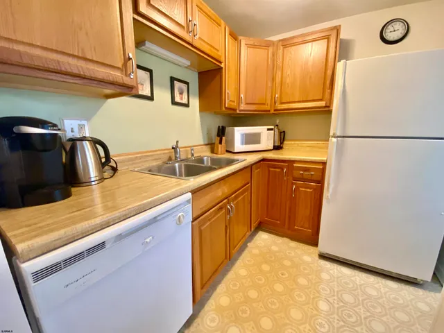 a kitchen with a sink a refrigerator and cabinets