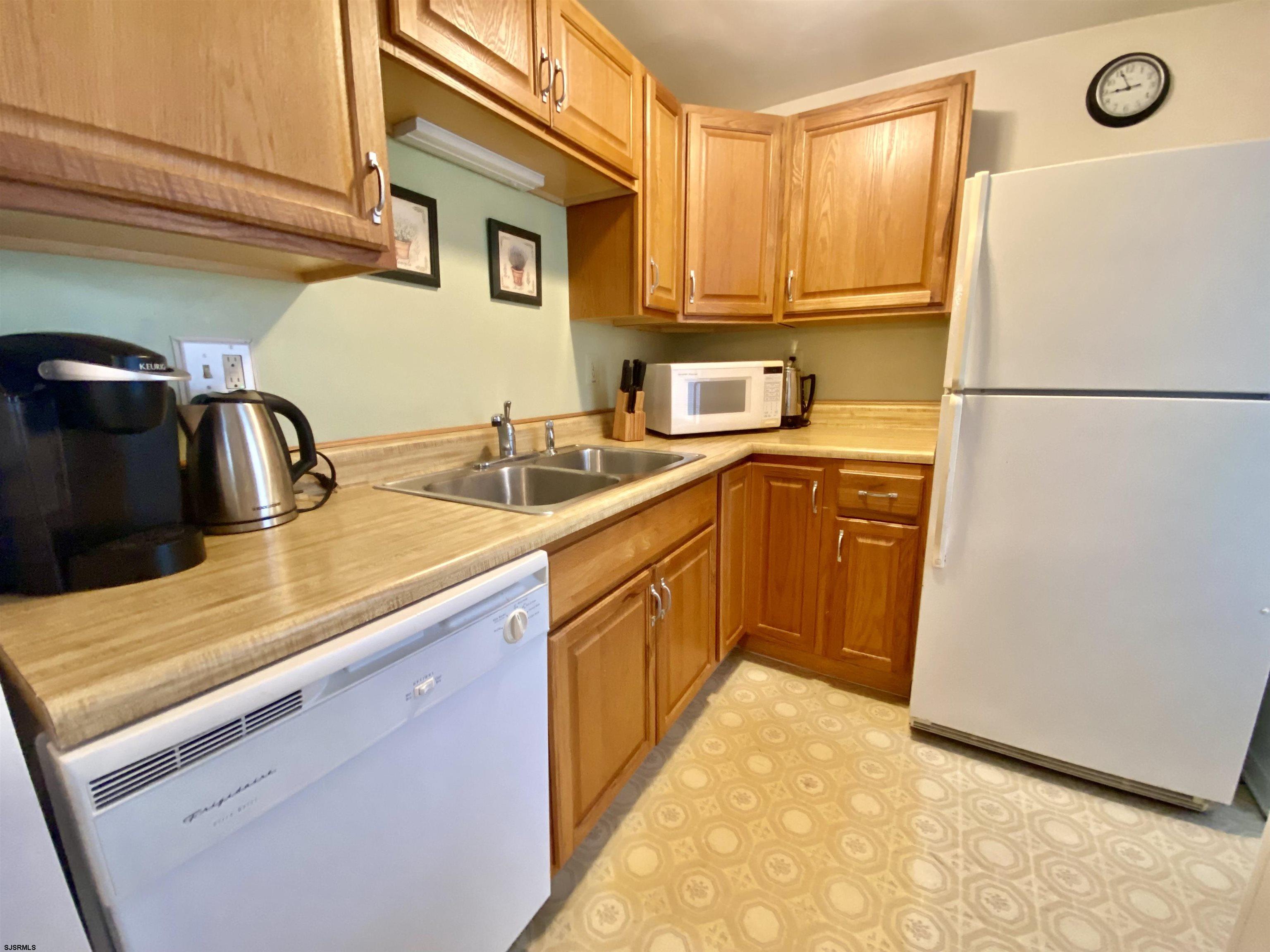 4 Ontario Drive, Unit B Brigantine, NJ 08203 - Photo 5 of 25 a kitchen with a sink a refrigerator and cabinets