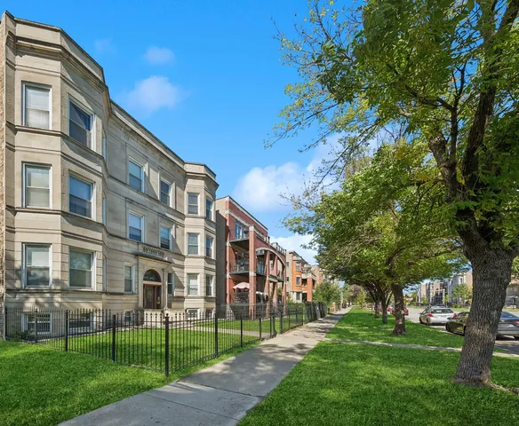 a view of a big building with a big yard and large trees