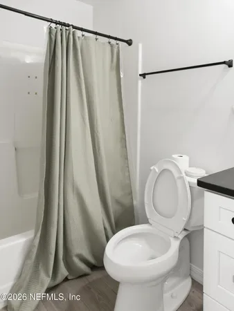 a bathroom with a granite countertop sink a mirror and a toilet