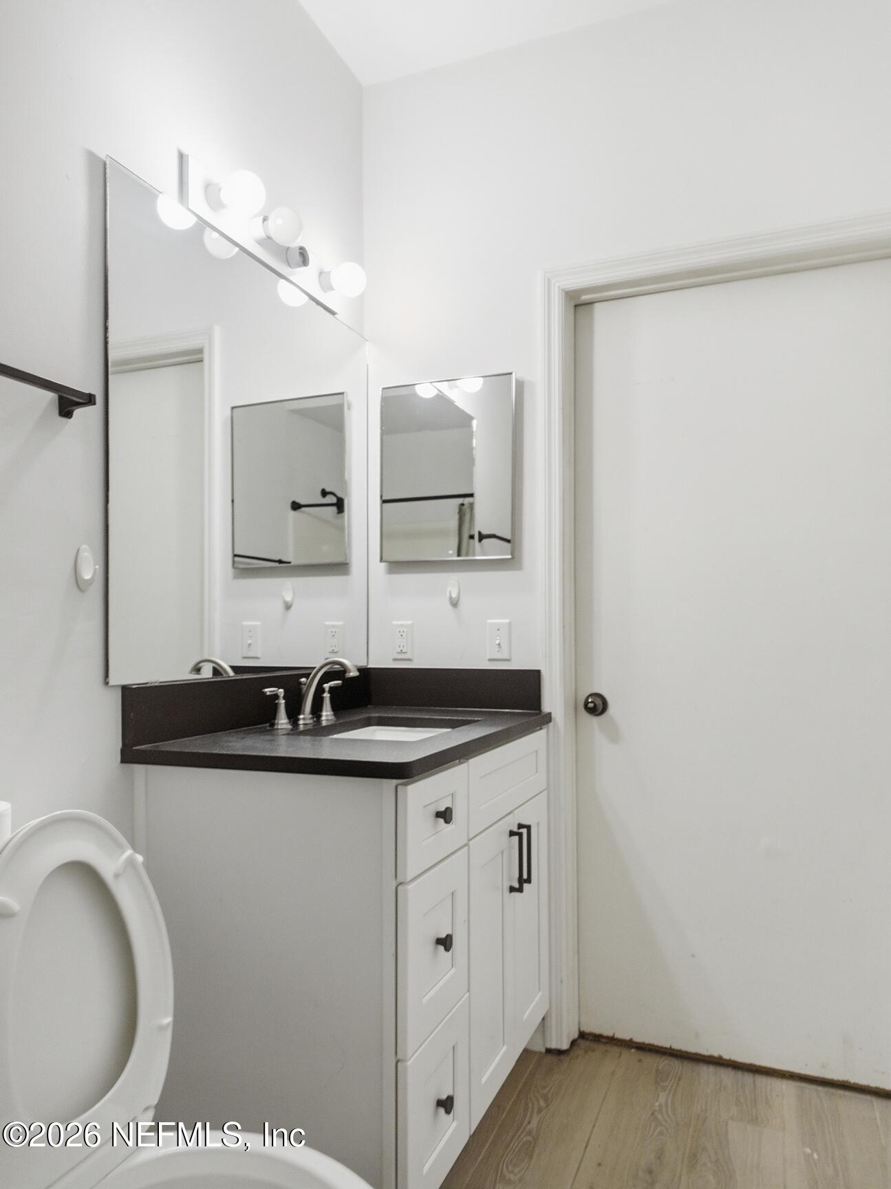 4700 Southwest Archer Road, Unit D27 Gainesville, FL 32608 - Photo 13 of 34 a bathroom with a granite countertop sink a mirror and a toilet