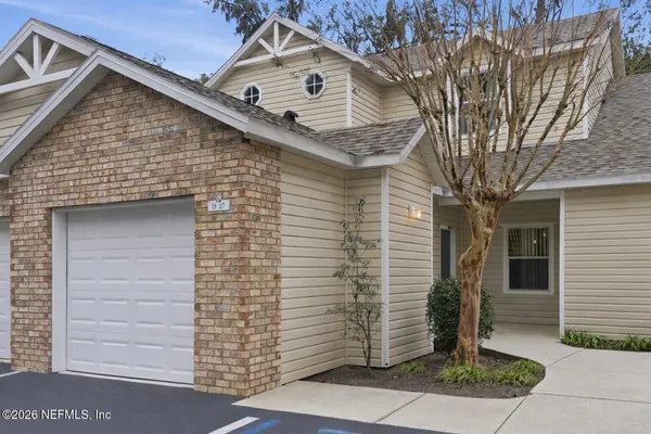 a front view of a house with a tree