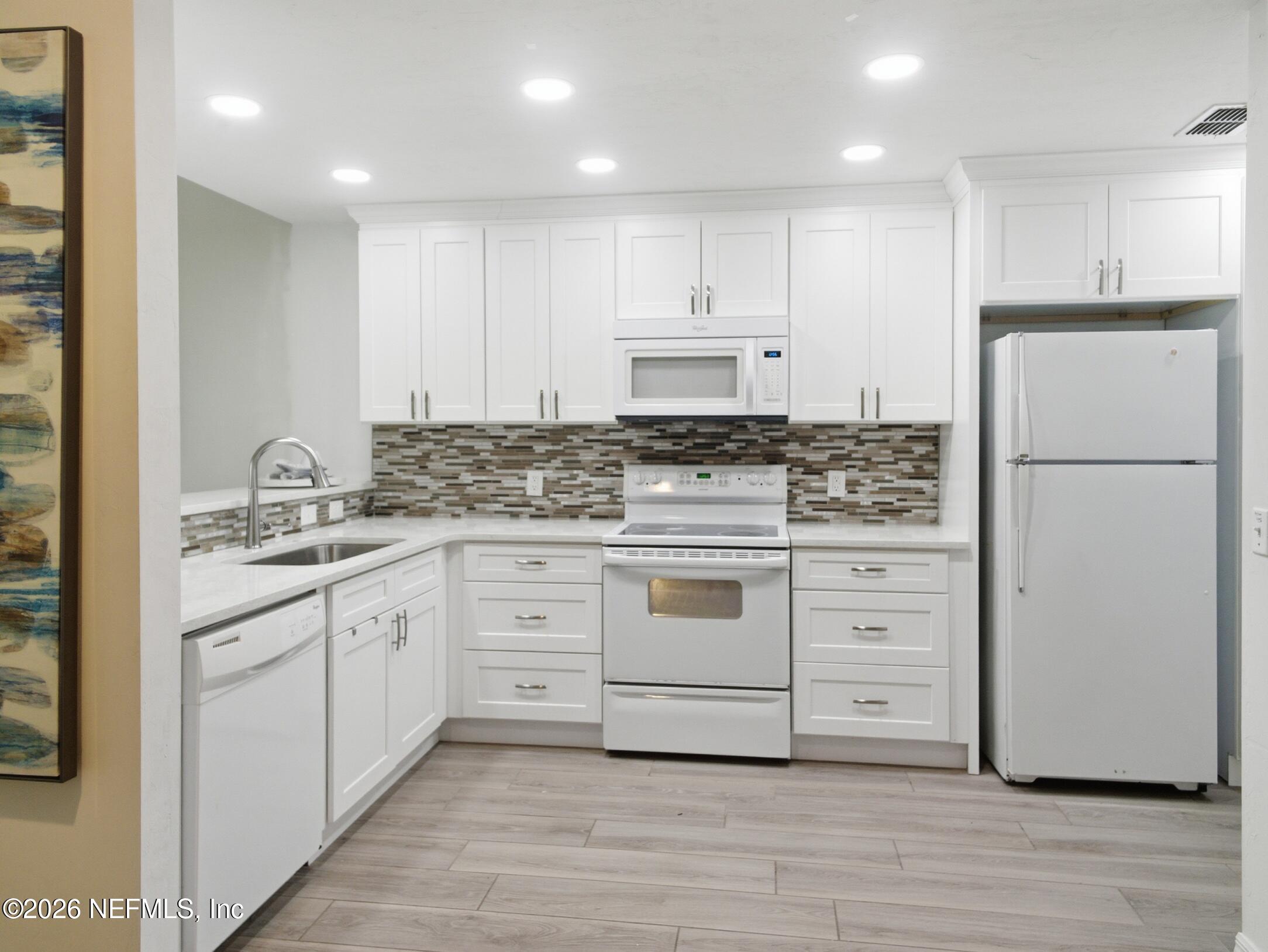 4700 Southwest Archer Road, Unit D27 Gainesville, FL 32608 - Photo 5 of 34 a kitchen with granite countertop white cabinets and white appliances