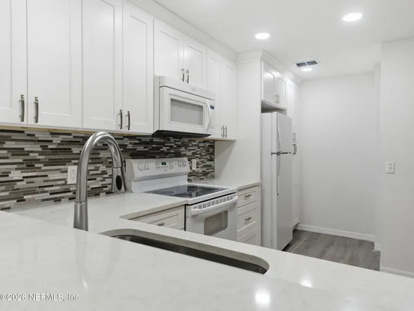 a kitchen with stainless steel appliances a refrigerator and a stove top oven