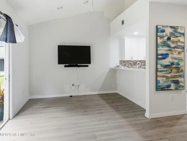 a view of a livingroom with wooden floor and a flat screen tv