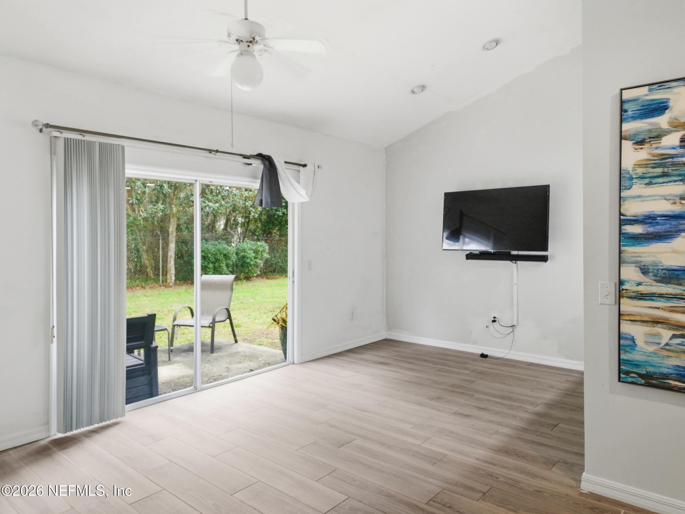 4700 Southwest Archer Road, Unit D27 Gainesville, FL 32608 - Photo 10 of 34 a view of a livingroom with wooden floor and a flat screen tv