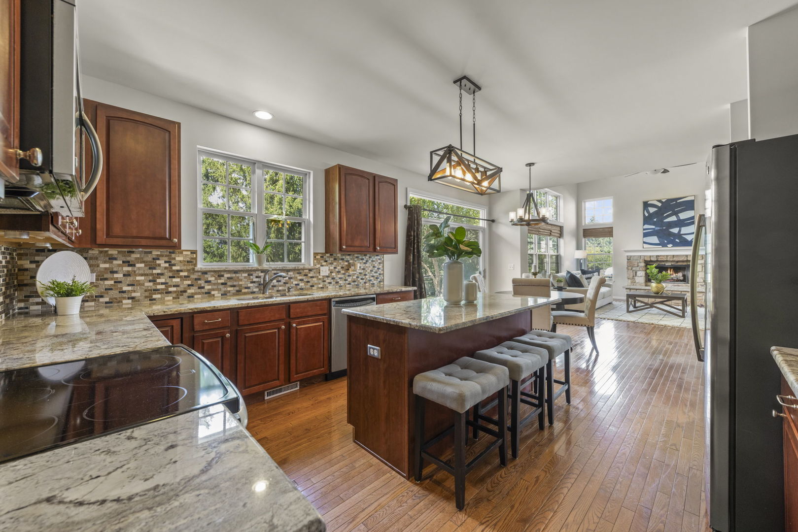 26500 Rustling Birch Way Plainfield, IL 60585 - Photo 12 of 37 a kitchen with stainless steel appliances granite countertop wooden cabinets a stove a sink a dining table and chairs