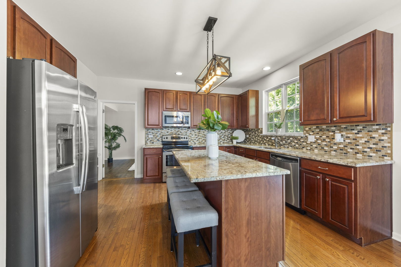 26500 Rustling Birch Way Plainfield, IL 60585 - Photo 10 of 37 a kitchen with stainless steel appliances granite countertop a refrigerator a sink dishwasher a stove and a dining table with wooden floor