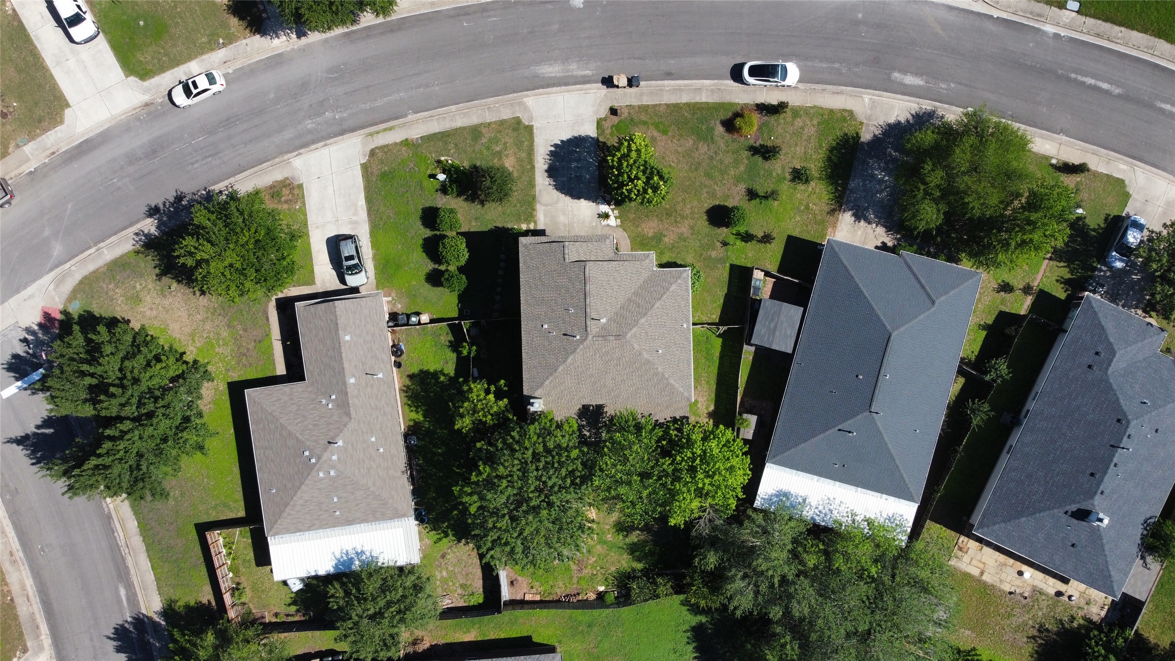 338 Spring Branch Loop Kyle, TX 78640 - Photo 32 of 36 An aerial perspective reveals a quiet residential street, showcasing several properties nestled amidst green lawns.
