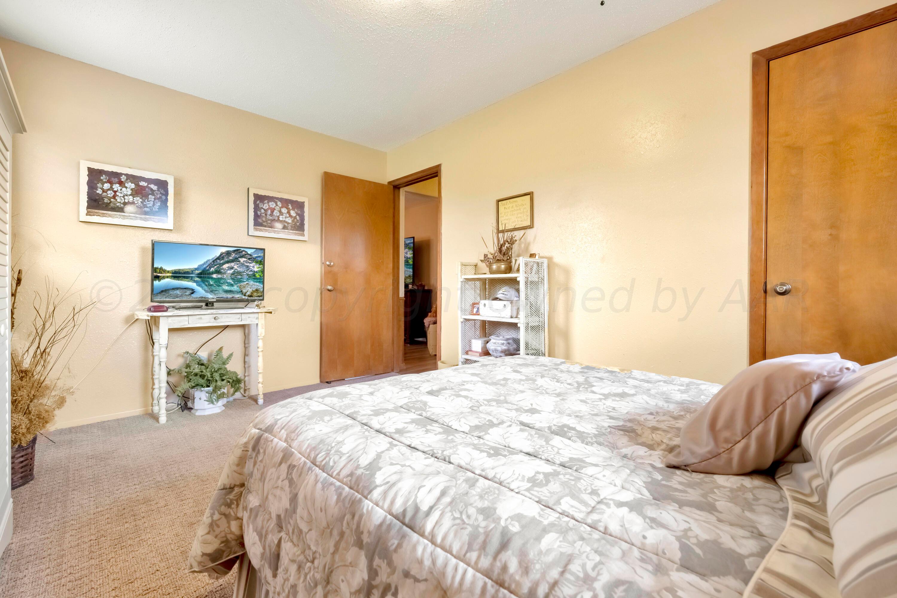 200 West Santa Fe Street Allison, TX 79003 - Photo 14 of 32 a bedroom with a bed and wooden floor