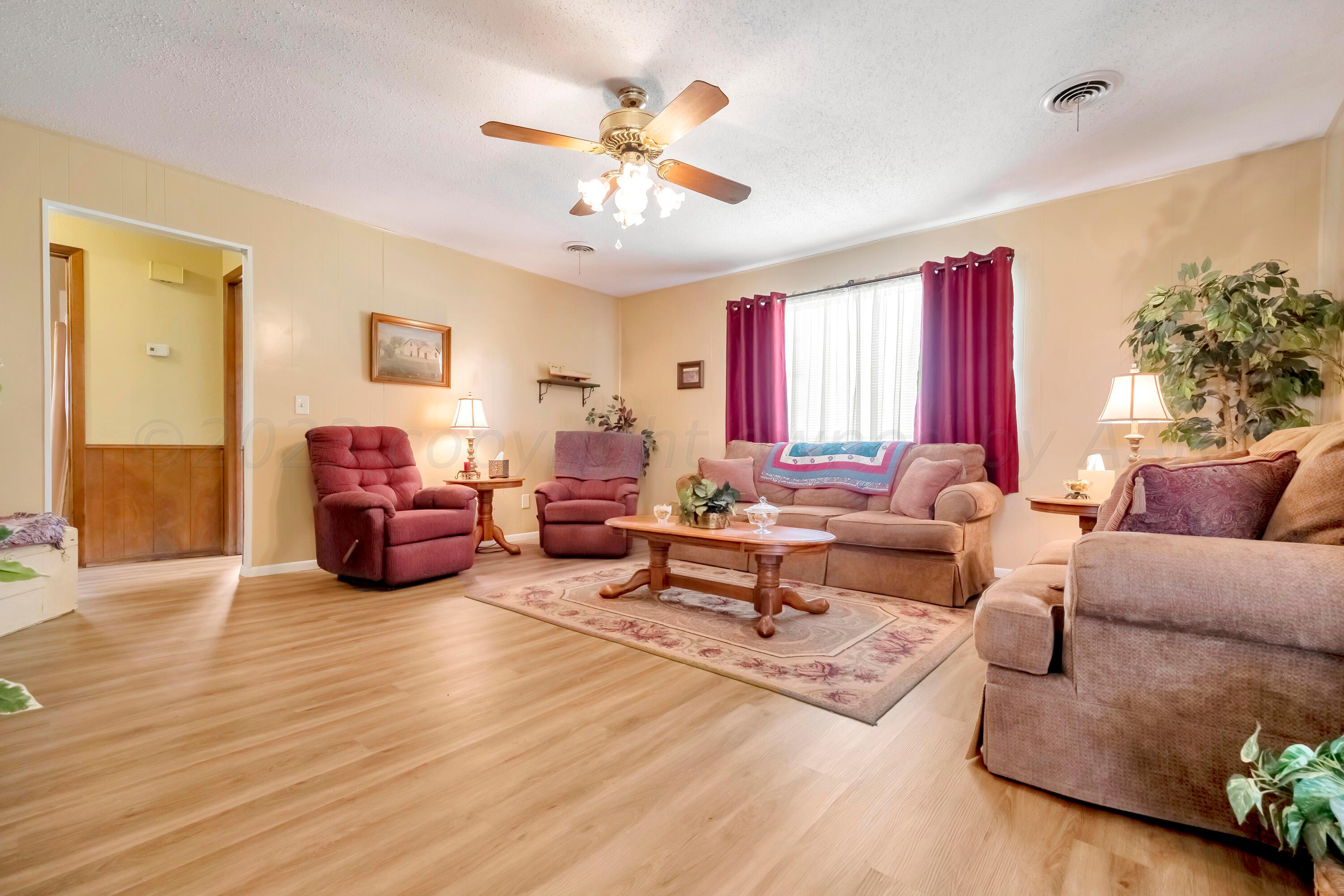 200 West Santa Fe Street Allison, TX 79003 - Photo 7 of 32 a living room with furniture or couch and a chandelier