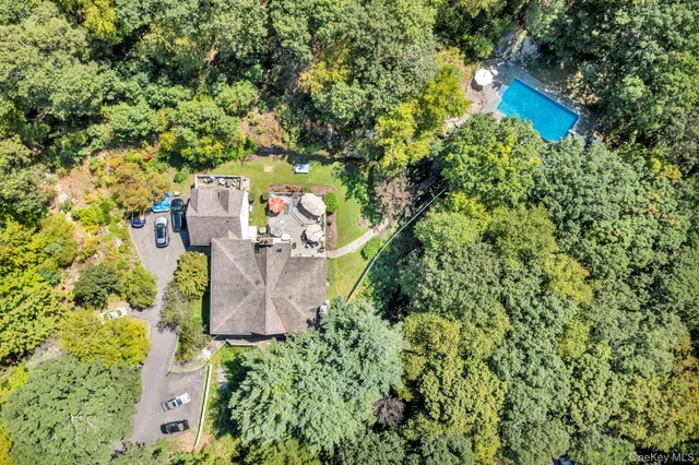 an aerial view of a house with a yard and large trees
