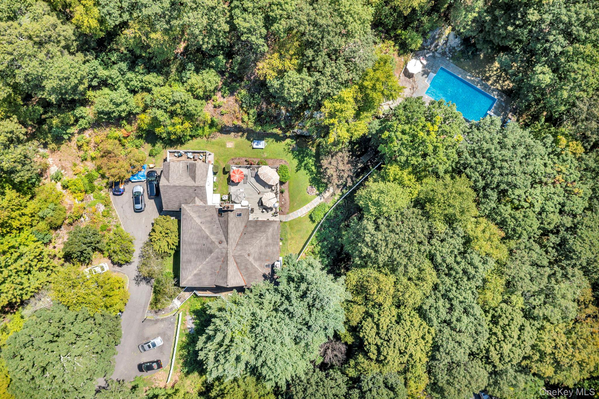 an aerial view of a house with a yard and large trees