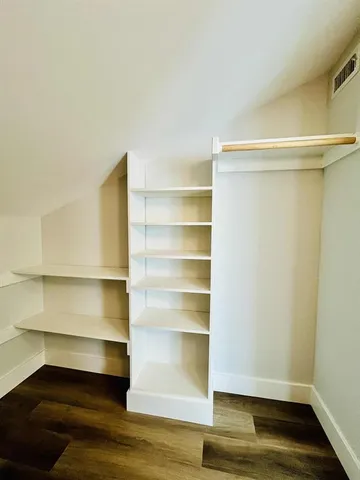a view of walk in closet with empty racks