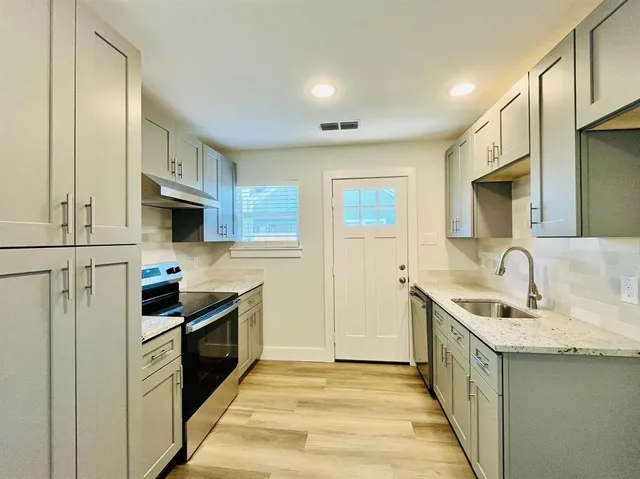 a kitchen with stainless steel appliances granite countertop a sink stove and refrigerator