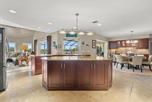 a large kitchen with kitchen island a sink table and chairs