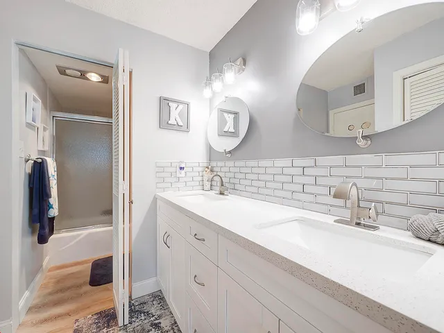 a bathroom with double vanity sink and two mirror