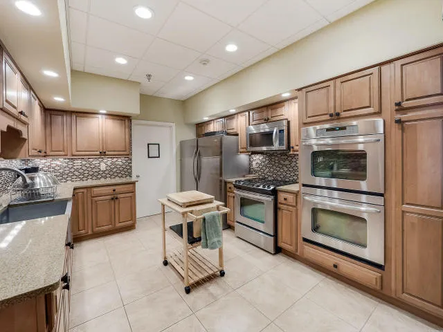 a kitchen with granite countertop a stove top oven and stainless steel appliances