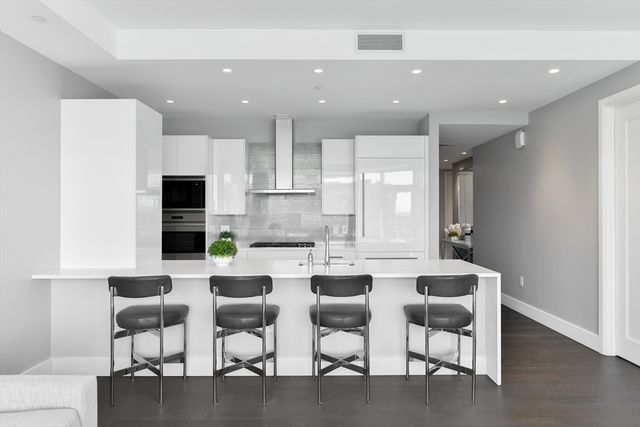 a kitchen with a dining table chairs cabinets and stainless steel appliances