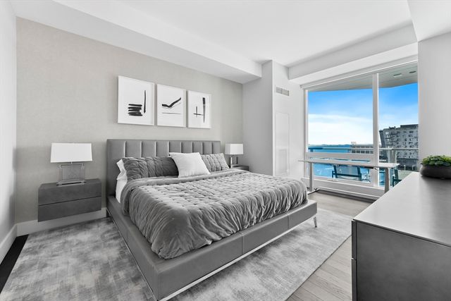 a bedroom with a bed and a large window