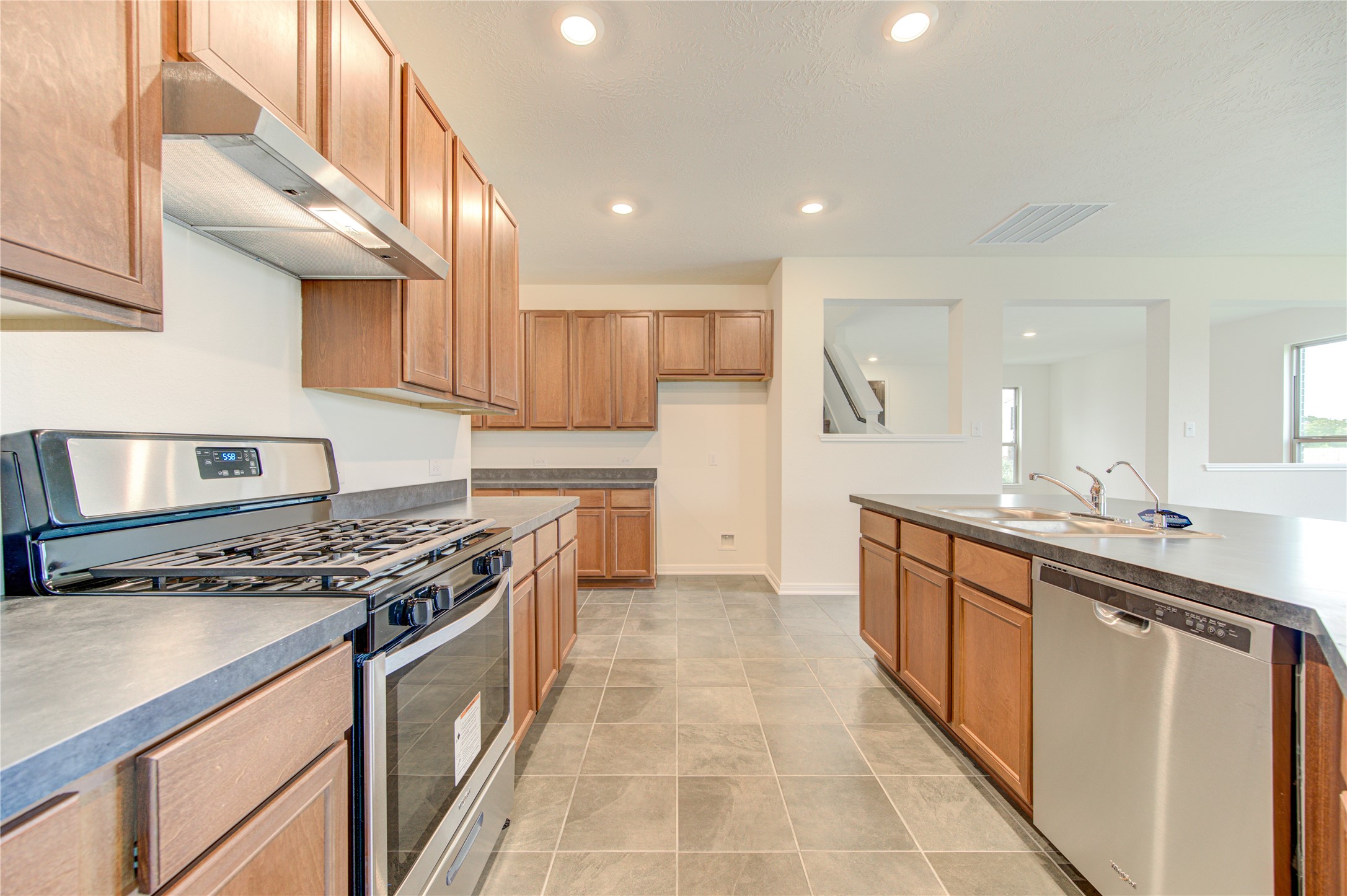 6120 Whitewing Road Rosenberg, TX 77469 - Photo 25 of 50 a kitchen with stainless steel appliances granite countertop a stove a sink and a microwave