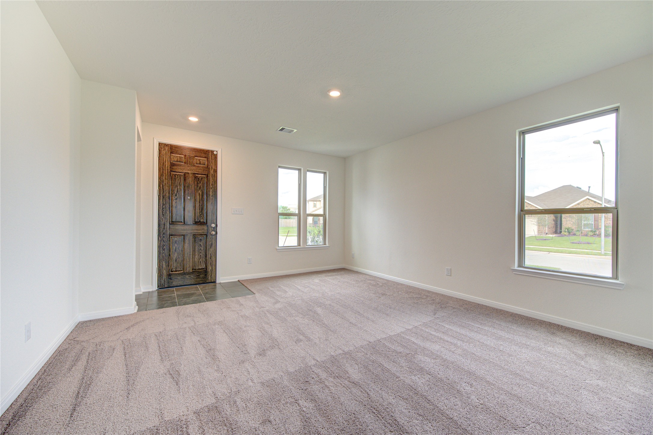 6120 Whitewing Road Rosenberg, TX 77469 - Photo 7 of 50 a view of an empty room with a window and a kitchen