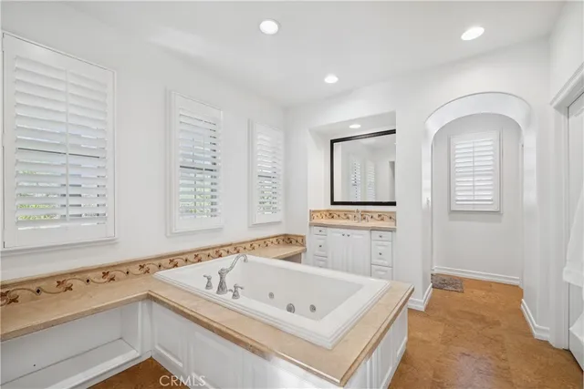 a bathroom with a tub a sink and a window