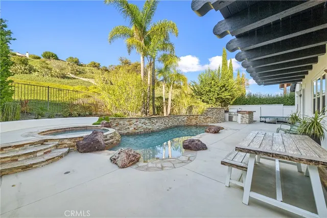 a view of backyard with swimming pool and outdoor seating