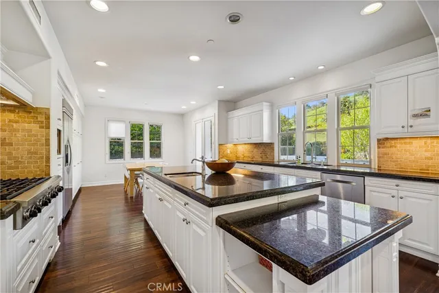 a kitchen with stainless steel appliances granite countertop a sink a stove and microwave