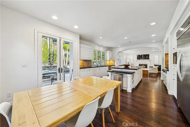 a kitchen with stainless steel appliances wooden floor dining table and chairs