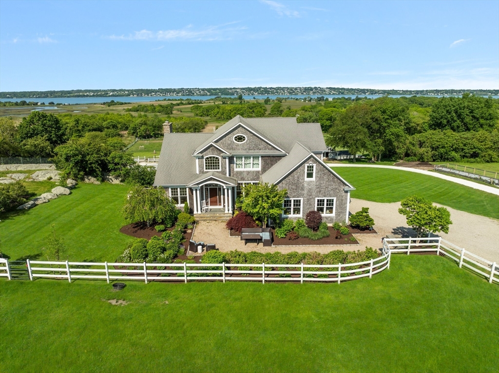 an aerial view of a house with swimming pool big yard and large trees