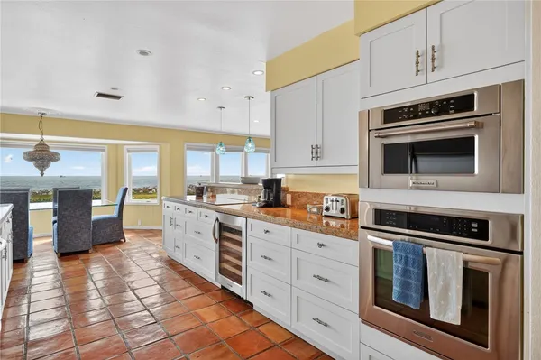 a kitchen with stainless steel appliances white cabinets a sink and a stove
