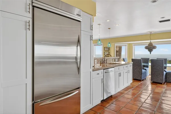 a kitchen with stainless steel appliances granite countertop a refrigerator and a sink