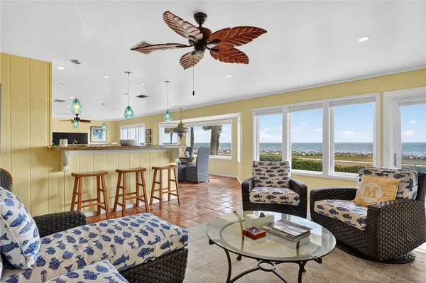 a living room with furniture ceiling fan and a large window