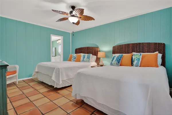 a bedroom with 2 bed and a chandelier