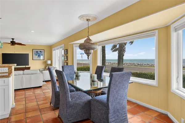 a dining room with furniture a flat screen tv and a floor to ceiling window
