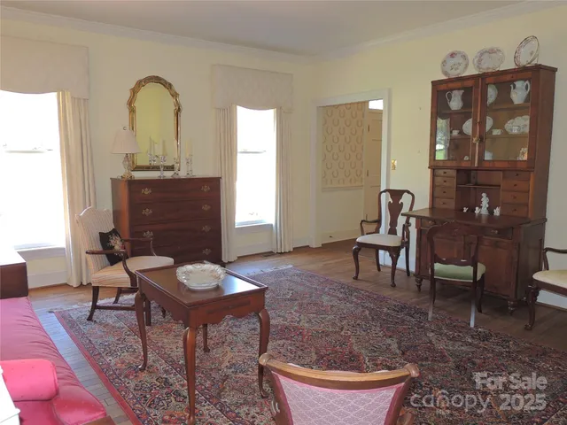 a living room with furniture a rug and a painting on the wall