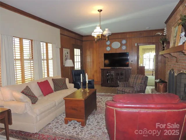 a living room with furniture a chandelier and a flat screen tv