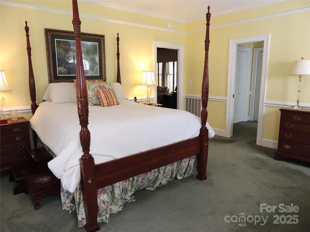 a bed sitting in a spacious bedroom next to a window