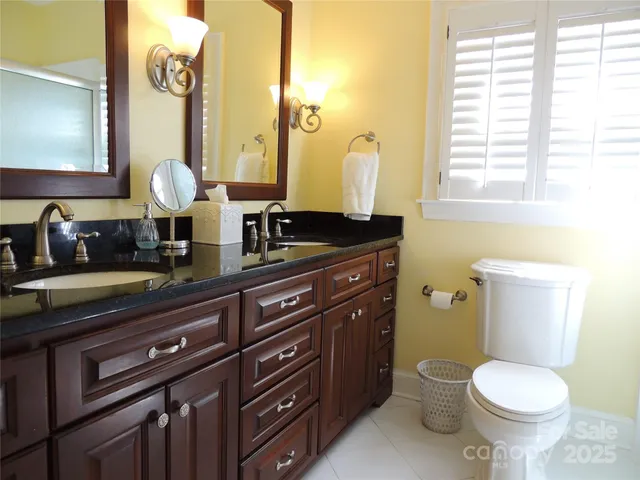 a bathroom with a granite countertop toilet sink and mirror